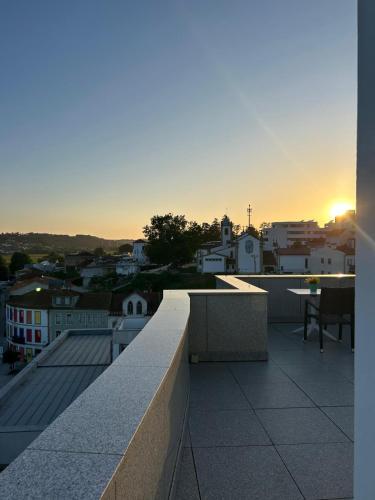 a view of a city from a balcony with the sunset at Hotel Conde de Agueda in Águeda