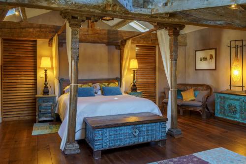 um quarto com uma cama grande e piso em madeira em Chambres d'hôtes Domaine de Ginouilhac em Le Taillan-Médoc