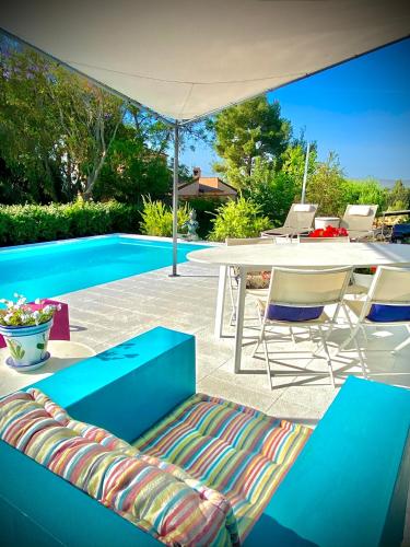 a patio with a table and chairs next to a pool at Yurta Arco Iris in Riba-Roja De Turia