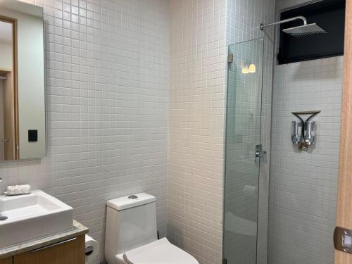 y baño con aseo y ducha acristalada. en Acogedor Departamento 2 Habitaciones, Alberca, Gym, en Guadalajara