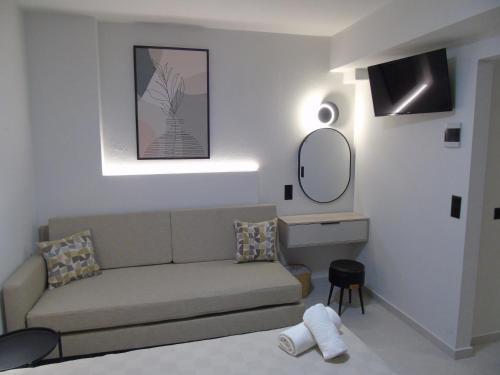 un salon avec un canapé et un miroir dans l'établissement Nostos Studios Golden Beach, à Chrysi Ammoudia