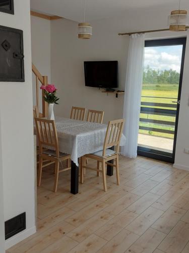 a dining room with a table and chairs and a television at Nowa Śluza Szóstka in Lipusz