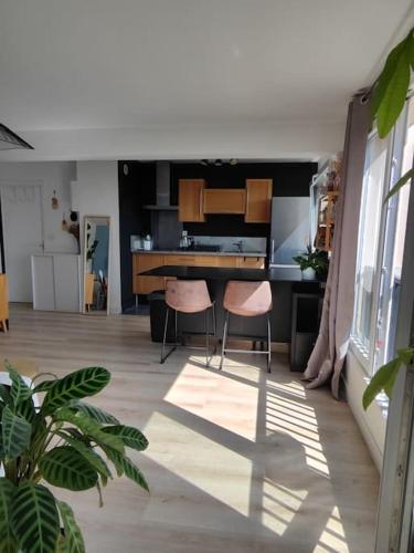 une cuisine avec deux chaises roses et une table dans l'établissement Appartement en résidence, à La Madeleine