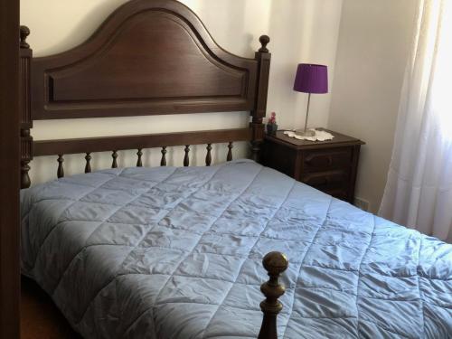 um quarto com uma cama grande e uma cabeceira em madeira em VIVENDA AZUL em Monchique