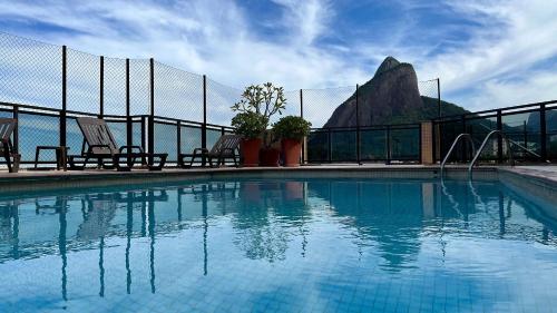 una piscina con una montagna sullo sfondo di 180m da PRAIA LEBLON, Piscina, Academia, Arrumação Diária etc. a Rio de Janeiro