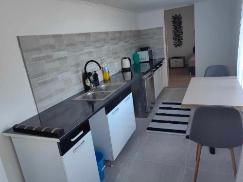 una pequeña cocina con fregadero y encimera en Sweety-Apartman en Mátészalka