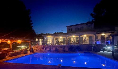 une piscine devant un immeuble la nuit dans l'établissement Villa Ganesh, à Le Rouret