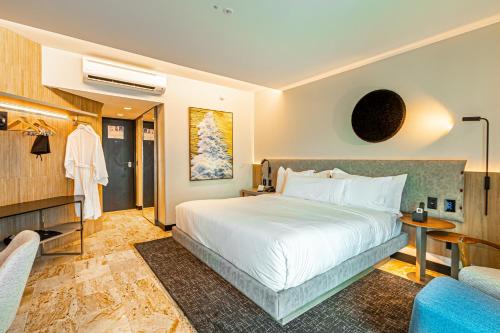 a bedroom with a large white bed and a couch at Hotel Atlante Plaza in Recife
