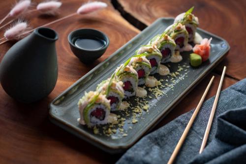 a plate of sushi on a wooden table with chopsticks at Sheraton Puerto Rico Resort & Casino in San Juan