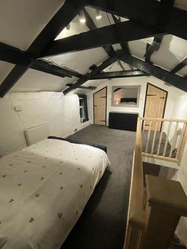 a bedroom with a large bed in a attic at Bumblebee Cottage in Redruth