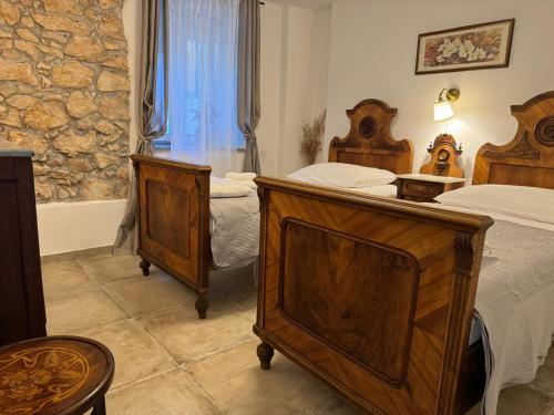 a bedroom with two beds and a window at Stone House Rosuja in Ivanje
