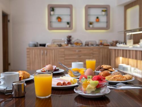 una mesa cubierta con platos de comida y zumo de naranja en Athinaiko Hotel en Heraclión