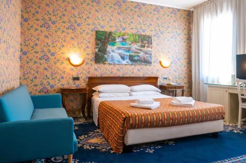 a hotel room with a bed and a couch and a bed at Hotel alla giustizia in Mestre