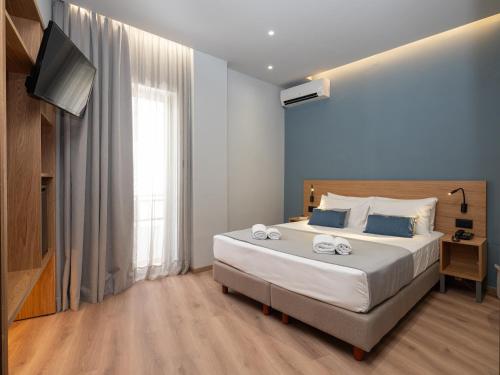 ein Schlafzimmer mit einem großen Bett und einem TV in der Unterkunft Athinaiko Hotel in Iraklio