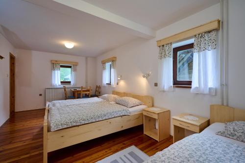 a bedroom with two beds and a table at The farmhouse Bevsek Osep in Solčava