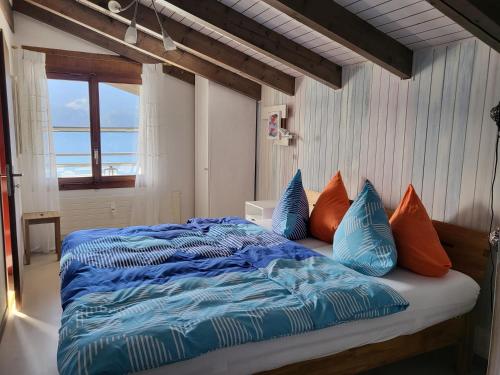 Hotel Platten Apartment في غيراسو: غرفة نوم مع سرير مع الوسائد الزرقاء والبرتقالية