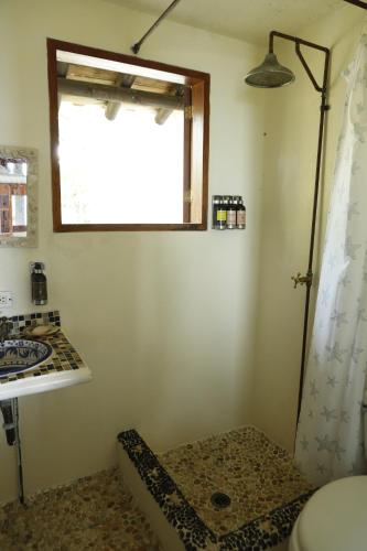 a bathroom with a shower and a sink and a window at Tintipan Cabana SalSiPuedes in Tintipan Island