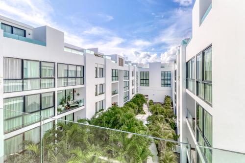 an exterior view of a white building with palm trees at Anah Suites #202 N in Playa del Carmen