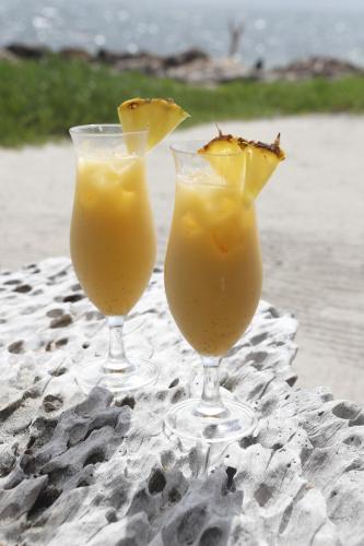 two glasses of orange juice sitting on the beach at Tintipan Cabana SalSiPuedes in Tintipan Island