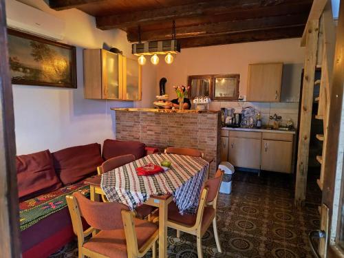 a kitchen with a table and a couch in a room at Vikendica Dunav i SAVA in Donji Milanovac