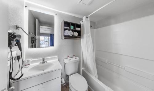 uma casa de banho com um WC, um lavatório e um espelho. em South Padre Island Lodge em South Padre Island