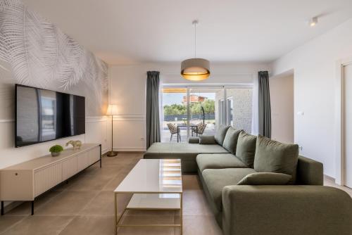 ein Wohnzimmer mit Sofa und Fernseher in der Unterkunft Villa Teuta in Kaštel Stari