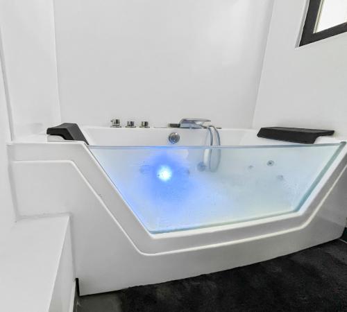 La salle de bains blanche est pourvue d'une baignoire blanche. dans l'établissement Balnéo-Ciné-Centre Historique à Troyes, à Troyes