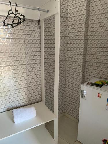 a kitchen with a white refrigerator and a shelf at Pousada Las Palmas in Guarujá