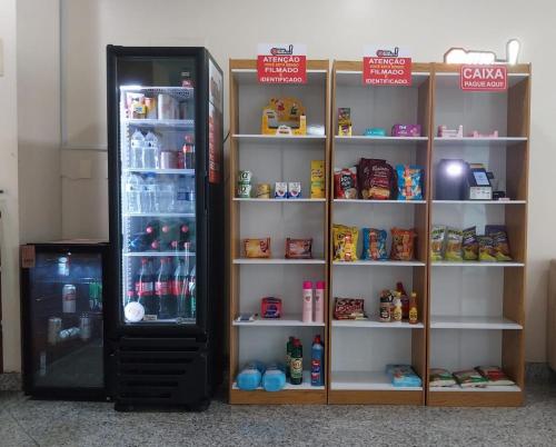 a refrigerator and shelves with food and drinks at Flat Via Park wi fi liberado in Campos dos Goytacazes