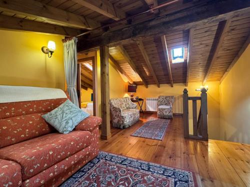 um quarto com um sofá e cadeiras num quarto em Casa Rural El Salvijo em Monte