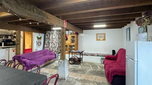 uma sala de estar com mobiliário roxo e um frigorífico em Casa Rural El Salvijo em Monte