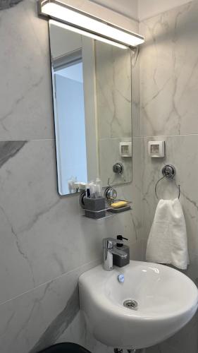 a white bathroom with a sink and a mirror at Przno Apartment Most Oliva in Vrijesno