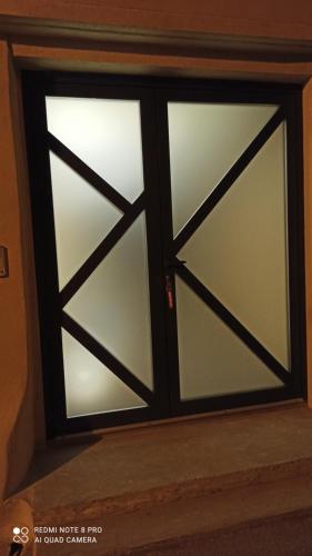 una puerta corredera de cristal con una ventana en una habitación en La Barrack Broc en Aimargues