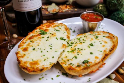 two pieces of cheese bread on a plate with a bottle of wine at Hotel Indigo Atlanta Downtown by IHG in Atlanta