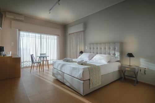 a bedroom with a large bed and a table and chairs at CHIOS HOTEL in Katarráktis