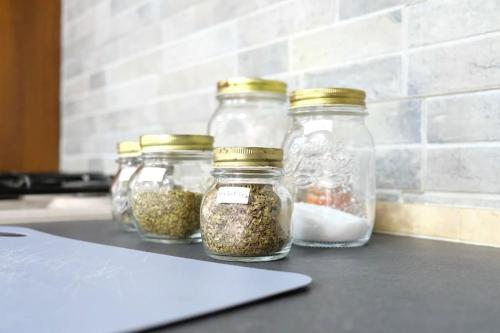 four glass jars filled with spices on a counter at Casa Davide in Torre Annunziata
