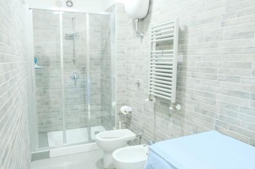 a white bathroom with a shower and a toilet at Casa Davide in Torre Annunziata