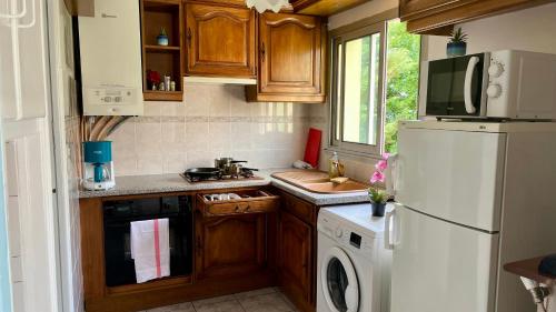 a kitchen with a white refrigerator and a sink at Appartement familial à Paris in Villejuif