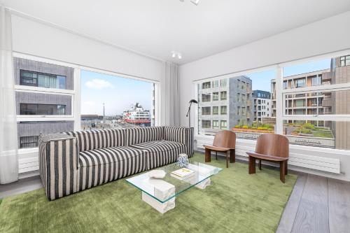 un salon avec un canapé et deux chaises et des fenêtres dans l'établissement Harbour View 2BR & 2BA City Center with Free Parking, à Reykjavik
