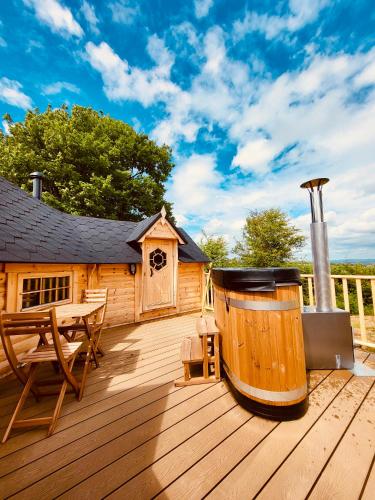 a wooden deck with a hot tub and a house at Stairway to Devon in High Bickington