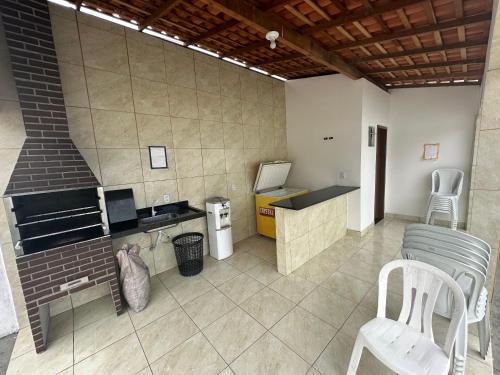 a kitchen with a stove and a counter with a chair at Casa de praia in São-José-do-Ribamar