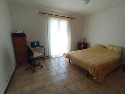 une chambre avec un lit, un bureau et une fenêtre dans l'établissement Maison entre Nice et Monaco, à Blausasc