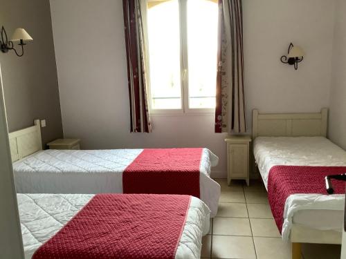 a bedroom with two beds with red and white blankets at Duplex (5pers) dans village vacances en Ardèche in Grospierres