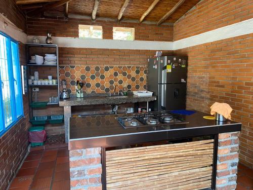a kitchen with a stove and a brick wall at Cabañas Villa Bayona in San Gil
