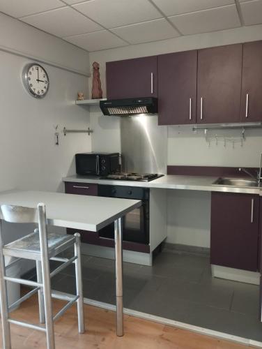 une cuisine avec une table et une horloge au mur dans l'établissement Appartement de Danseuse Etoile, à Bordeaux