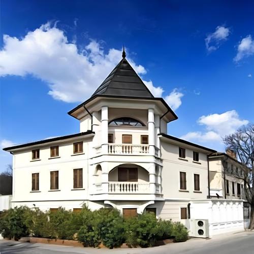 un edificio bianco con tetto nero di Hotel Paquito a Nova Gorica