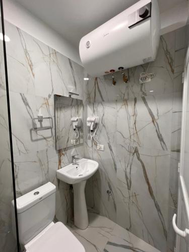a bathroom with a sink and a toilet and a mirror at Zhuraj Apartments in Shkodër