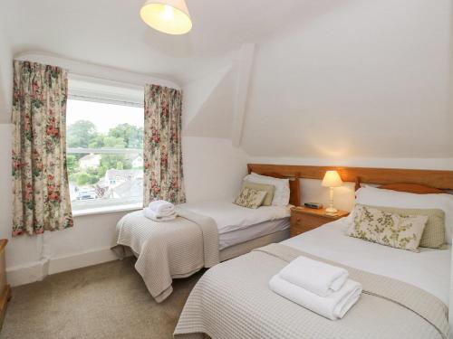 1 dormitorio con 2 camas y ventana en Prospect Lodge, en Portinscale