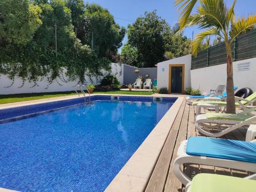 una piscina con sedie a sdraio accanto a una casa di Vicentina Rooms by Casas do Alentejo ad Almograve