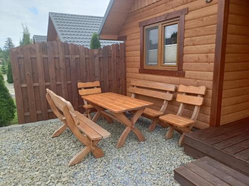 a wooden table and two chairs and a table and bench at Zielona Dolina Hoczew in Hoczew